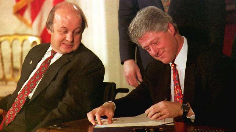 Clinton assinando a Lei Brady, que implementou a checagem prévia na venda de armas