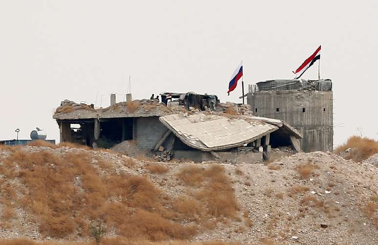 Bandeiras da R&uacute;ssia e da S&iacute;ria perto de vilarejo s&iacute;rio de Zor Magar, vistas da cidade fronteiri&ccedil;a turca de Karkamis
23/10/2019
REUTERS/Huseyin Aldemir