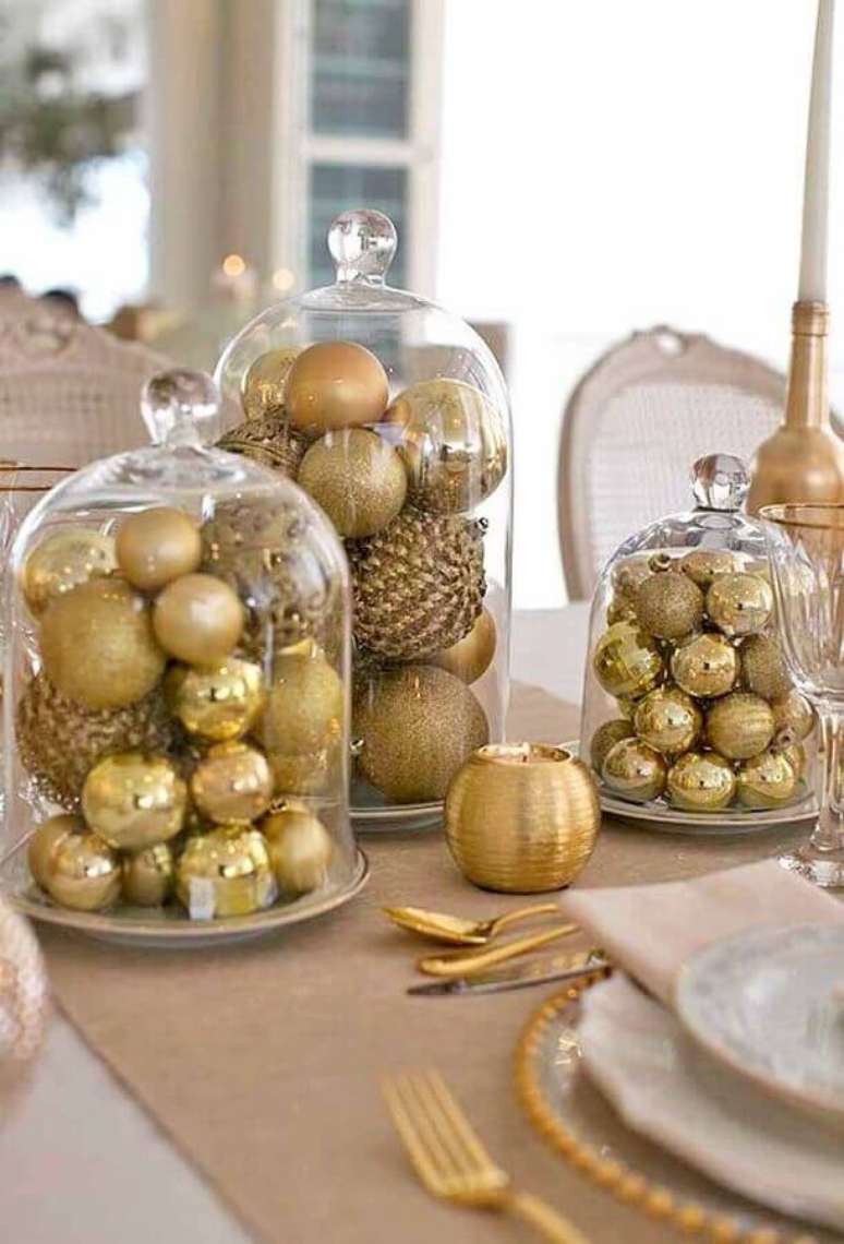 11. Arranjos com bolas douradas dentro de redomas de vidro para decoração de natal simples – Foto: Paty Scaringella