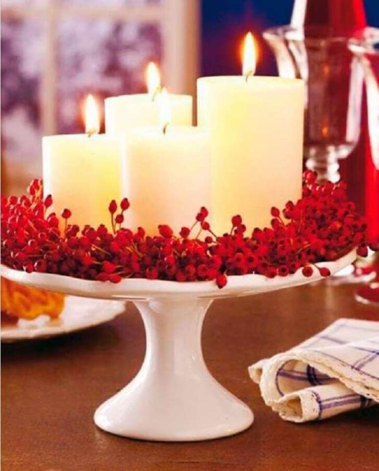 65. Decoração natalina simples com arranjo de velas e plantinhas vermelhas – Foto: Vera Moraes