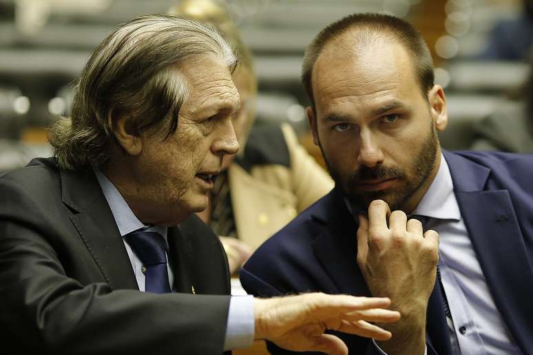 O deputado, Eduardo Bolsonaro (PSL-SP), conversa com o presidente do PSL, Luciano Bivar (PSL-PE), no plenário da Câmara, em Brasília (DF)