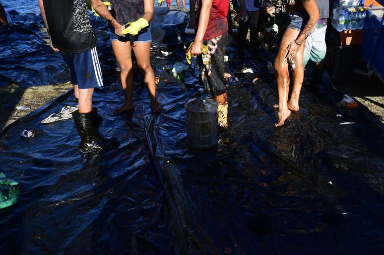  Voluntários se mobilizam para a retirada das manchas de óleo que chegaram à praia do Janga, no município do Paulista (PE), na região metropolitana do Recife, na tarde desta quarta-feira (23)