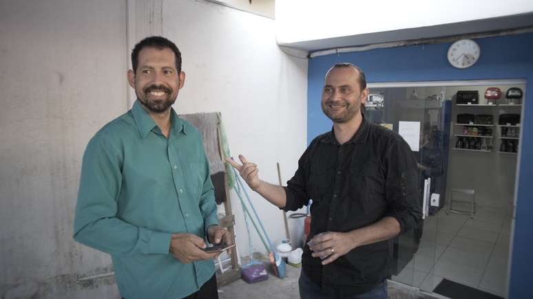 Para complementar a renda, Cleber (esq.) vende perfumes aos passageiros