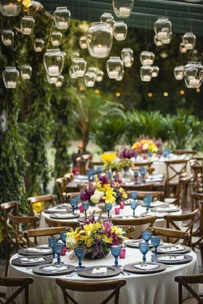 64. Decoração de casamento no campo com velas suspensas e arranjos de flores nas mesas dos convidados – Foto: Luxury Wedding
