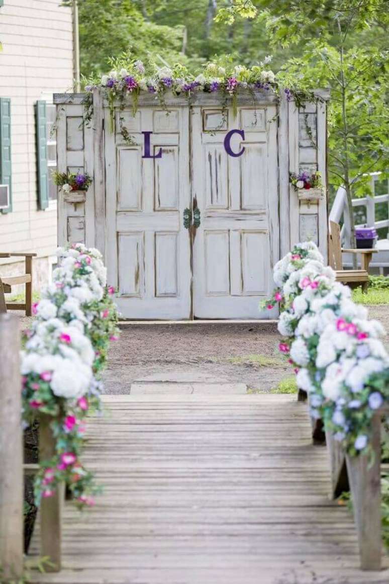 40. Decoração rústica para cerimônia de casamento no campo com porta antiga e arranjo de flores – Foto: Pinterest