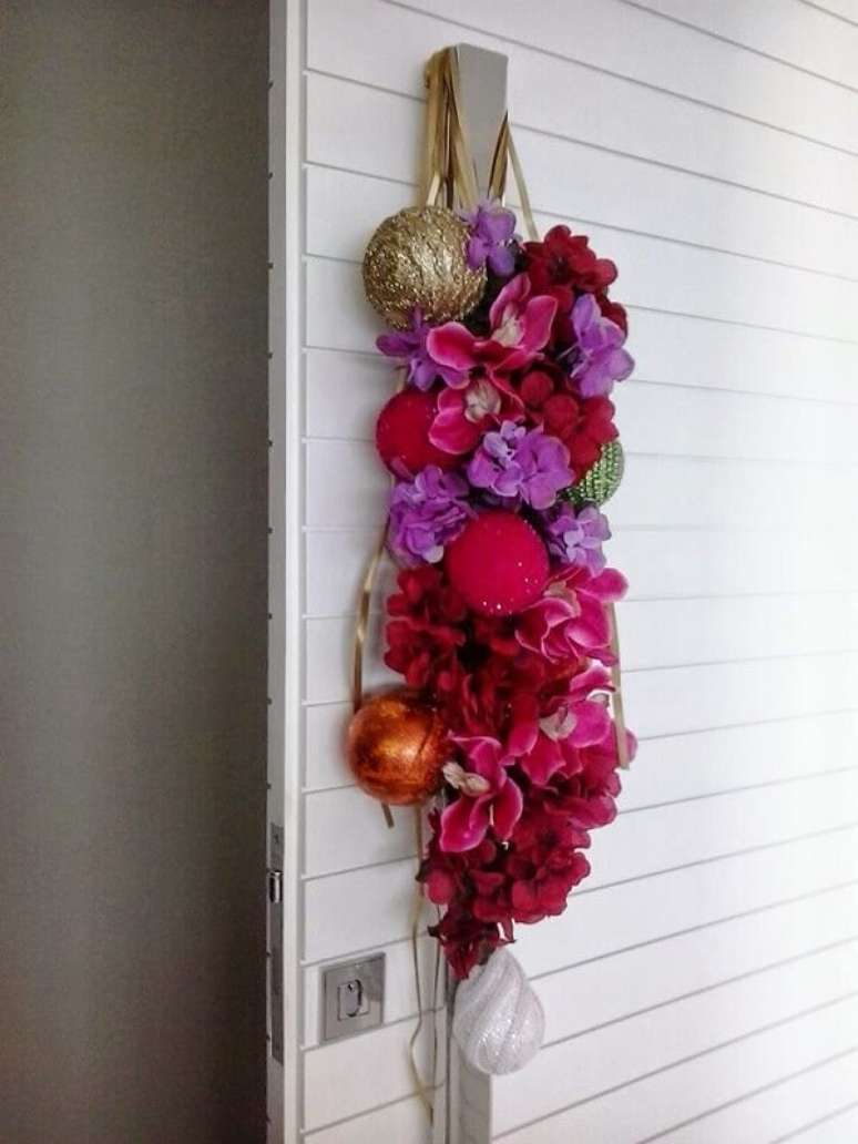 19. Enfeite de porta para natal feito com flores e posicionado na maçaneta. Fonte: Dona Debora