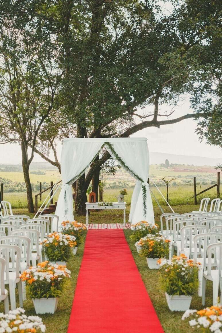 48. Decora&ccedil;&atilde;o para casamento simples no campo com tapete vermelho e arranjo de flores do campo &ndash; Foto: Pinterest