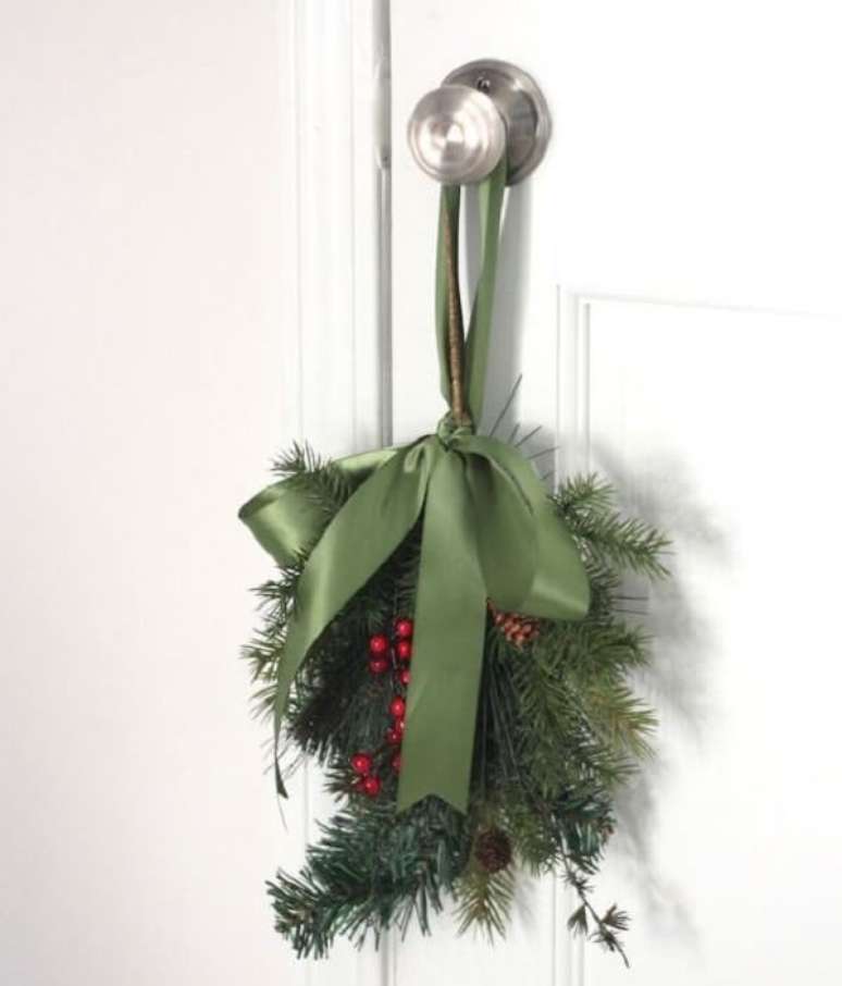 24. Enfeite de natal para porta feito com ramos e posicionado na maçaneta. Fonte: Pinterest
