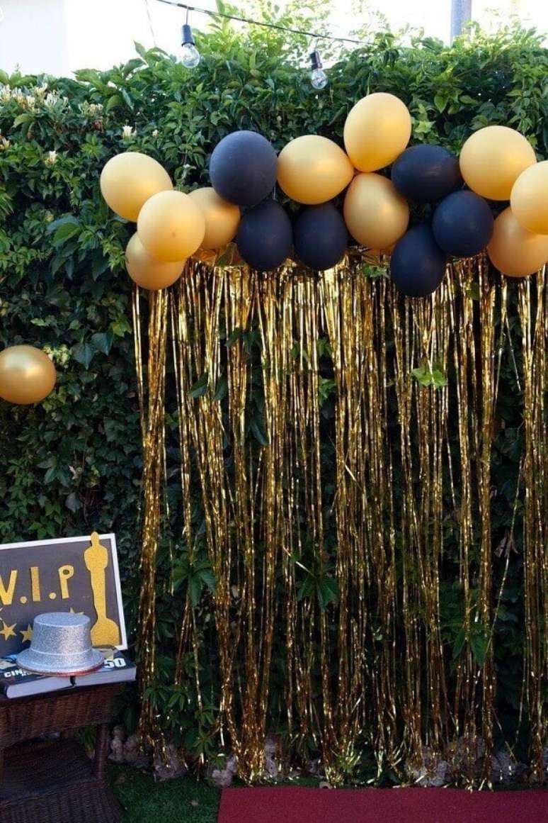 26. Decoração de festa de réveillon ao ar livre com balões e cortina de fios dourados – Foto: Pinterest