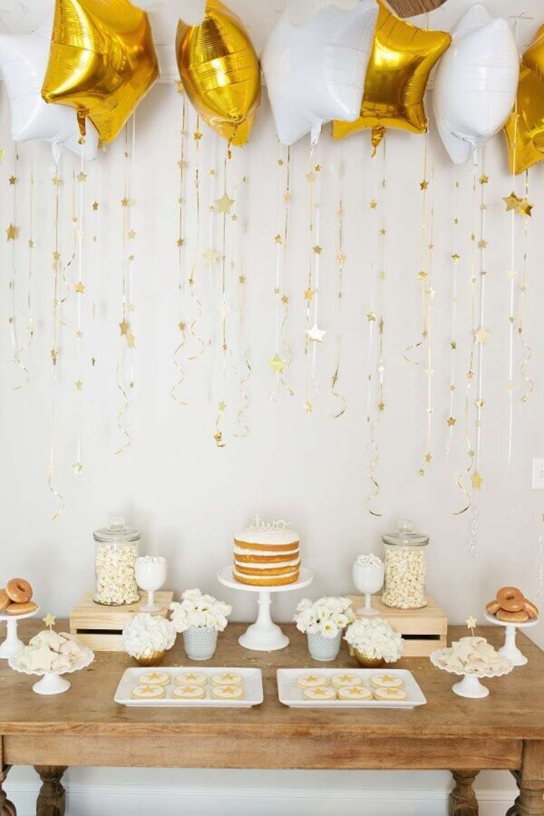 28. Decoração de réveillon com balões em formato de estrelas brancas e douradas – Foto: Suzanne Carey Photography
