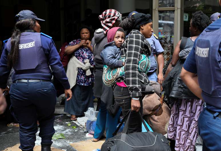 Refugiados carregam suas posses ap&oacute;s pol&iacute;cia dispersar acampamento pr&oacute;ximo a ag&ecirc;ncia da ONU na Cidade do Cabo
30/10/2019
REUTERS/Sumaya Hisham