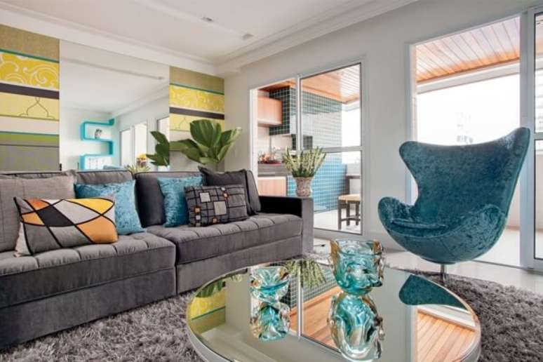 38. Sala de estar com sofá suede cinza e poltrona em tom azul turquesa. Fonte: Pinterest