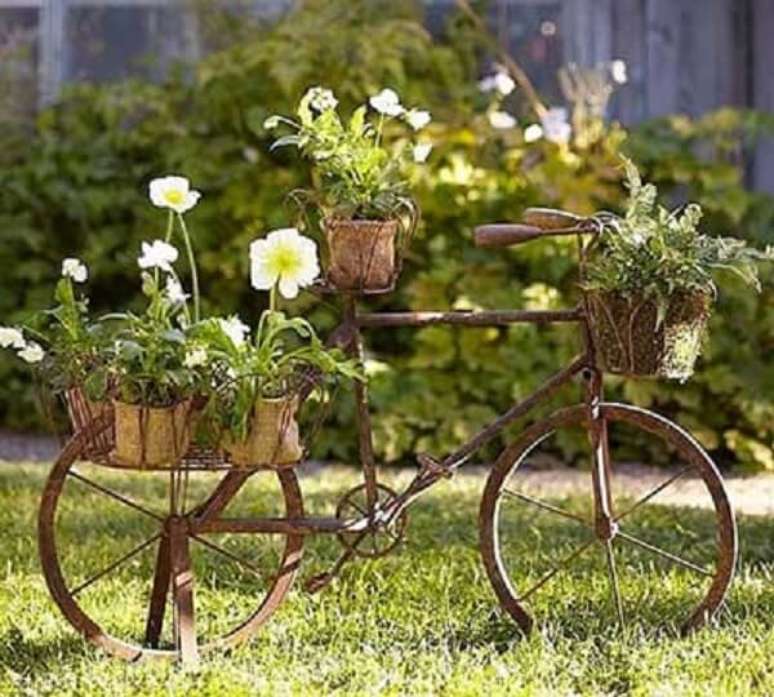 52. As bicicletas podem formam lindos enfeites para jardim e servir de apoio para os vasos. Fonte: Pinterest