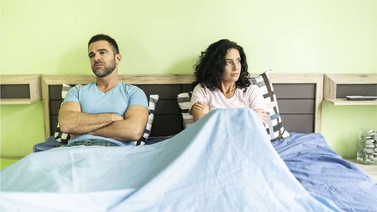 Couple looking sitting on a bed