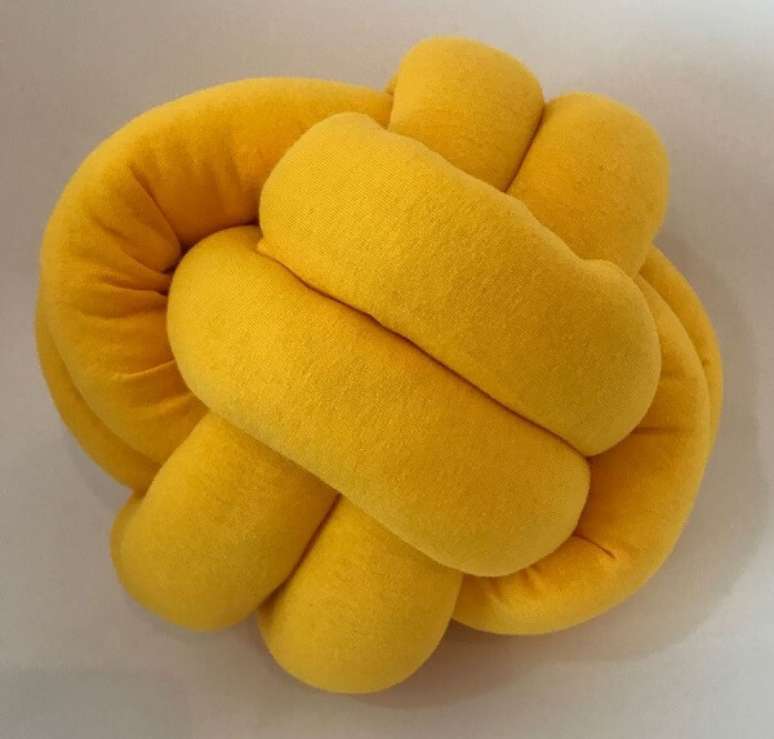 8. Almofada do tipo nó na cor amarela traz alegria para a decoração. Fonte: Pinterest