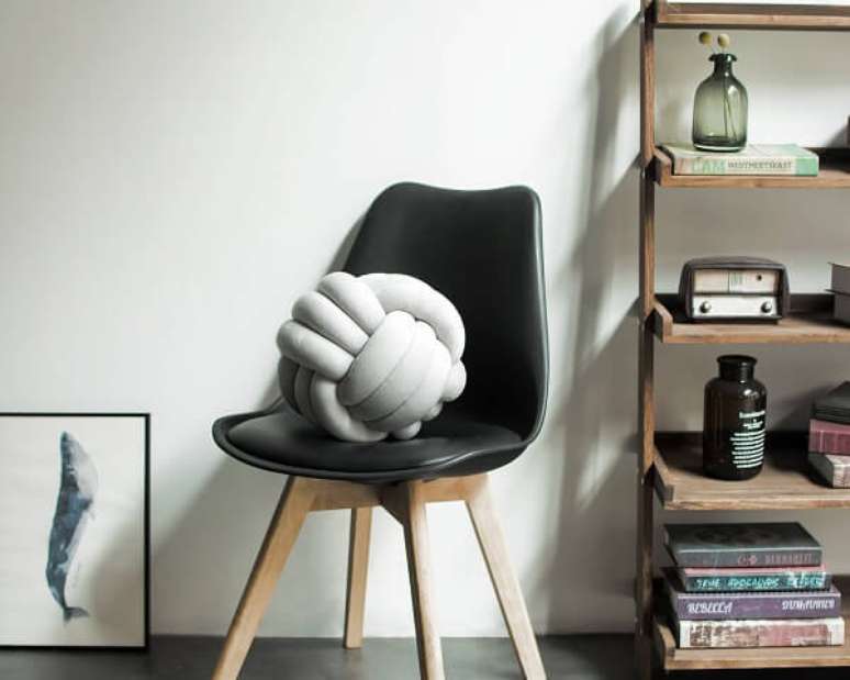 9. A almofada do tipo nó branca se destaca sobre a cadeira preta. Fonte: Pinterest