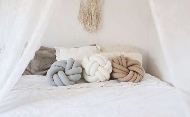 28. Diferentes tonalidades neutras de almofada de nó complementam a decoração do quarto. Fonte: Pinterest