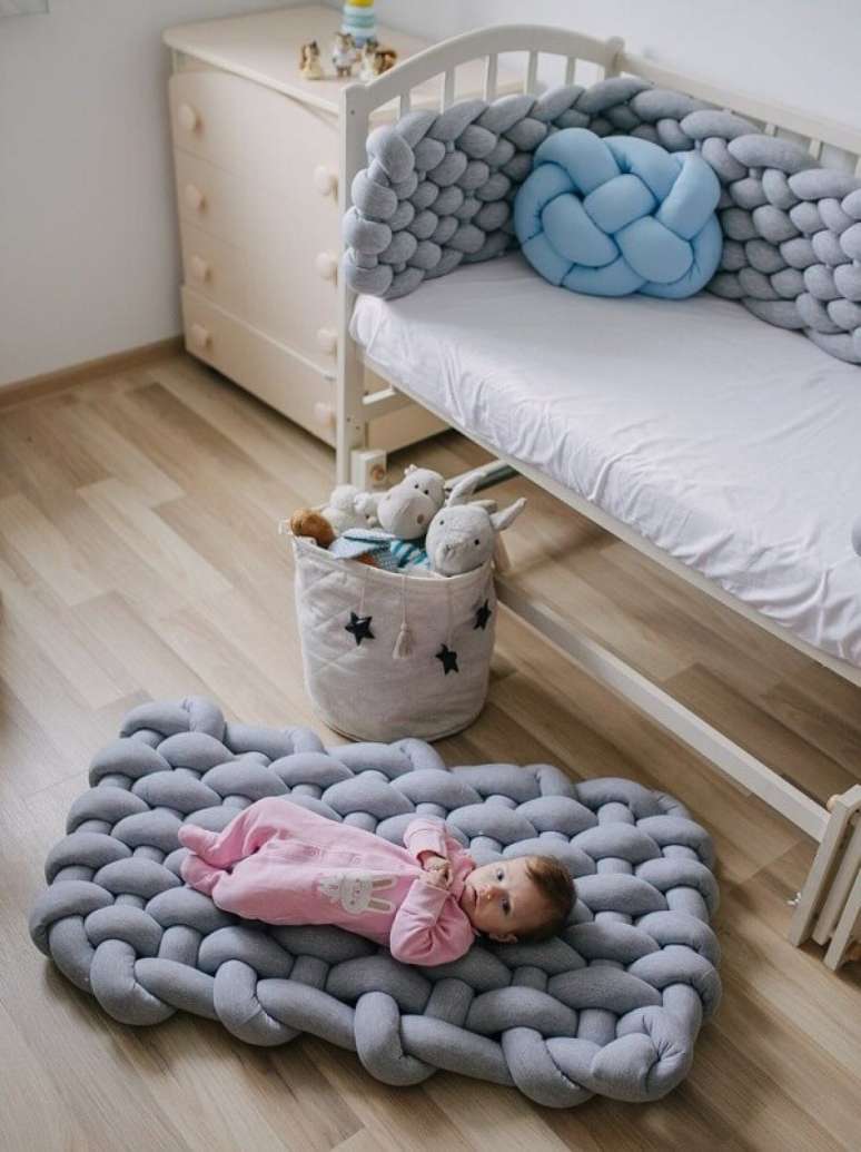 4. A almofada de nó com manta cinza complementa a decoração do quarto de bebê. Fonte: Pinterest