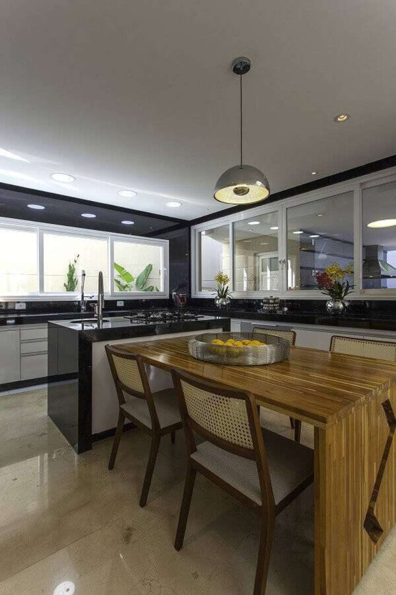 38. Decora&ccedil;&atilde;o para cozinha planejada grande com ilha e mesa de madeira &ndash; Foto: Iara Kilaris