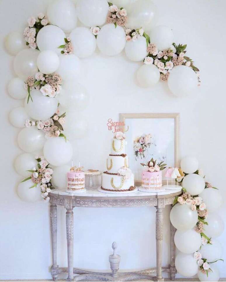 22. Linda decoração para mesa de festa de aniversário branca e rosa com arranjo de bexigas e flores – Foto: Imagens e moldes