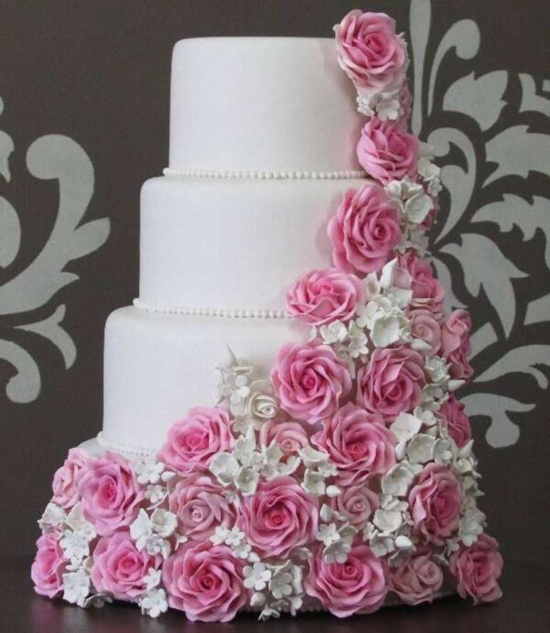 107. Bolo de casamento fake com fundo branco e acabamento em flores. Fonte: Elo7