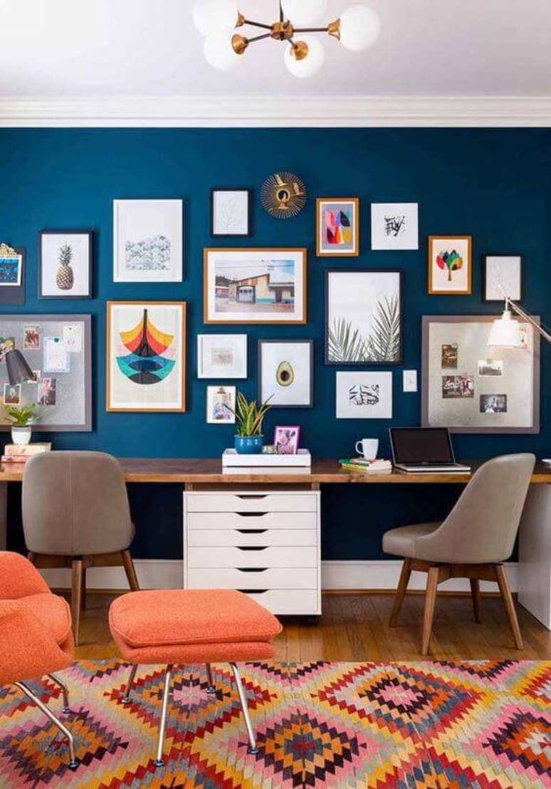 6. Escritório com parede azul, quadros coloridos e poltronas laranjas – Por: Ideias Decor