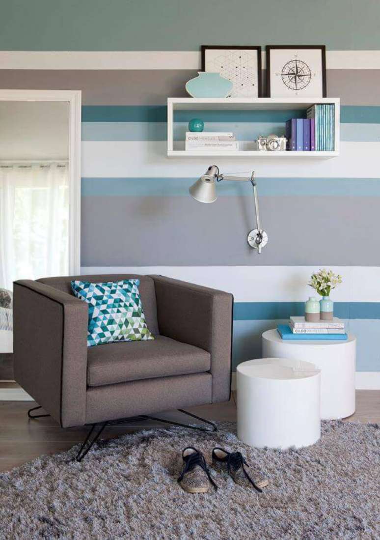 23. Parede azul listrada em tons neutros e poltrona confort&aacute;vel &ndash; Por: Mobly
