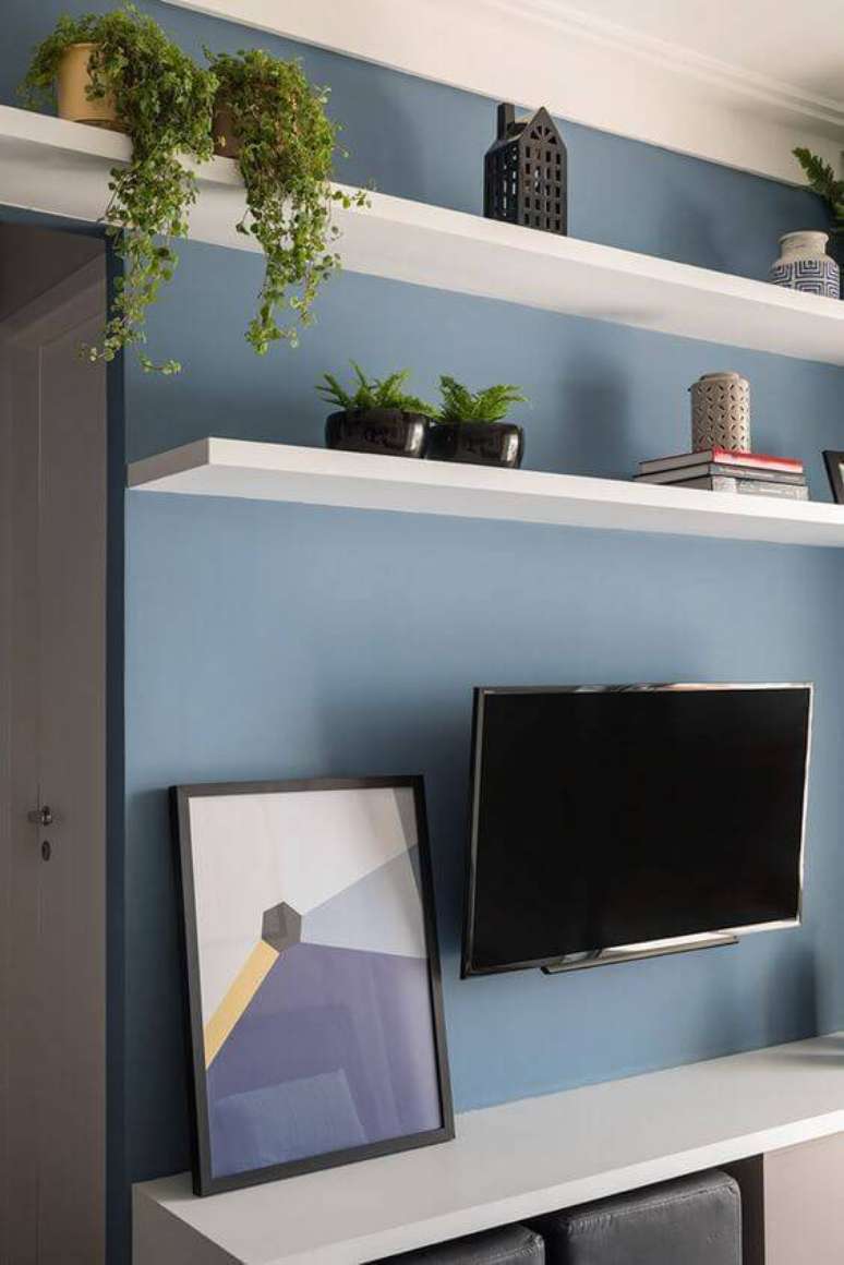 25. Parede azul com rack branca na sala de estar – Por: Marina Carvalho