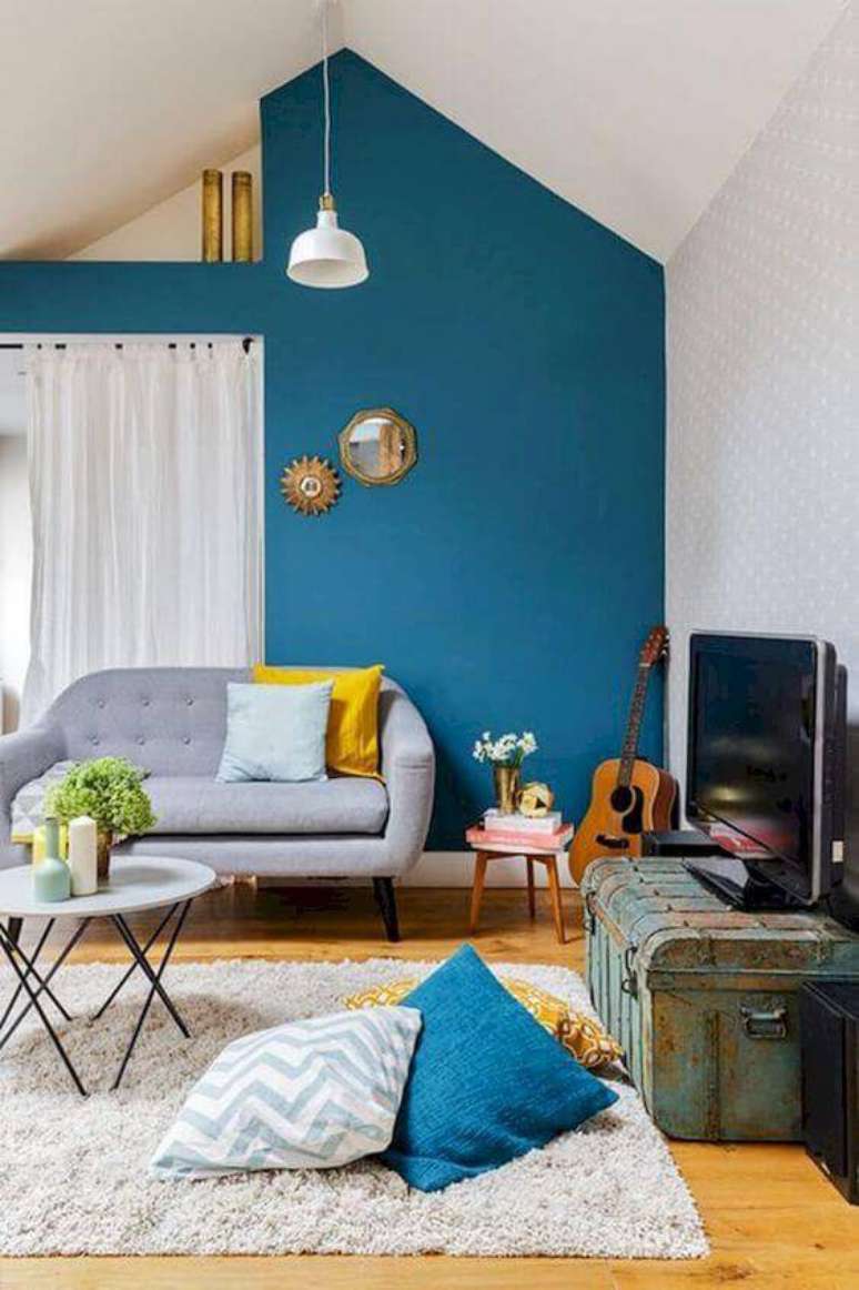 57. Sala de estar com sof&aacute; vintage e detalhes em azul e amarelo &ndash; Por: Elona Home