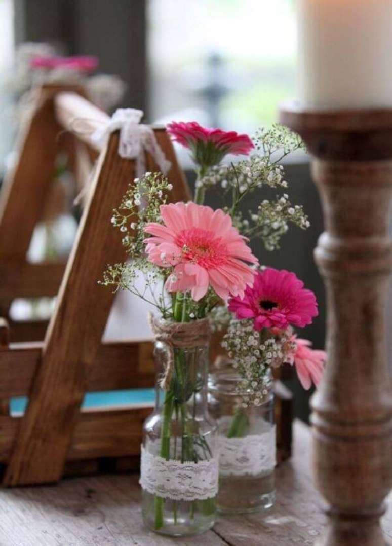 18. Vidraçaria com detalhes em renda recebem flores de gérbera em tom de rosa. Fonte: Pinterest