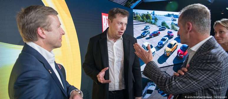 Elon Musk entre seus concorrentes alemães Oliver Zipse (esq.), da BMW, e Herbert Diess, da Volkswagen