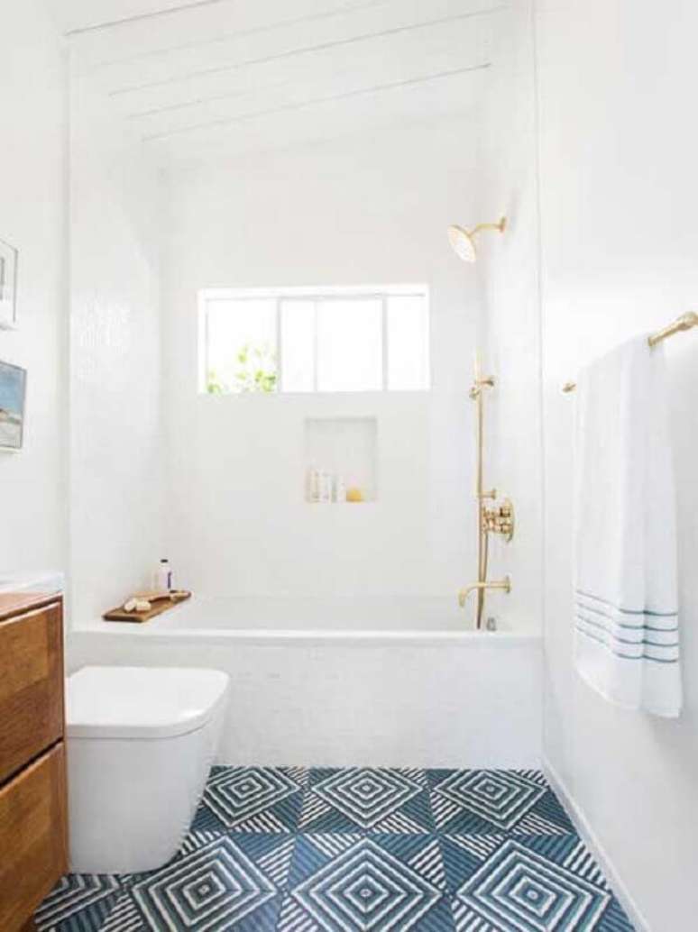 38. Decoração com piso geométrico azul para banheiro branco com gabinete de madeira – Foto: Sua Decoração