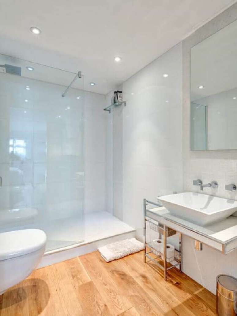 47. Decoração simples para banheiro todo branco com piso de madeira – Foto: Home & Garden