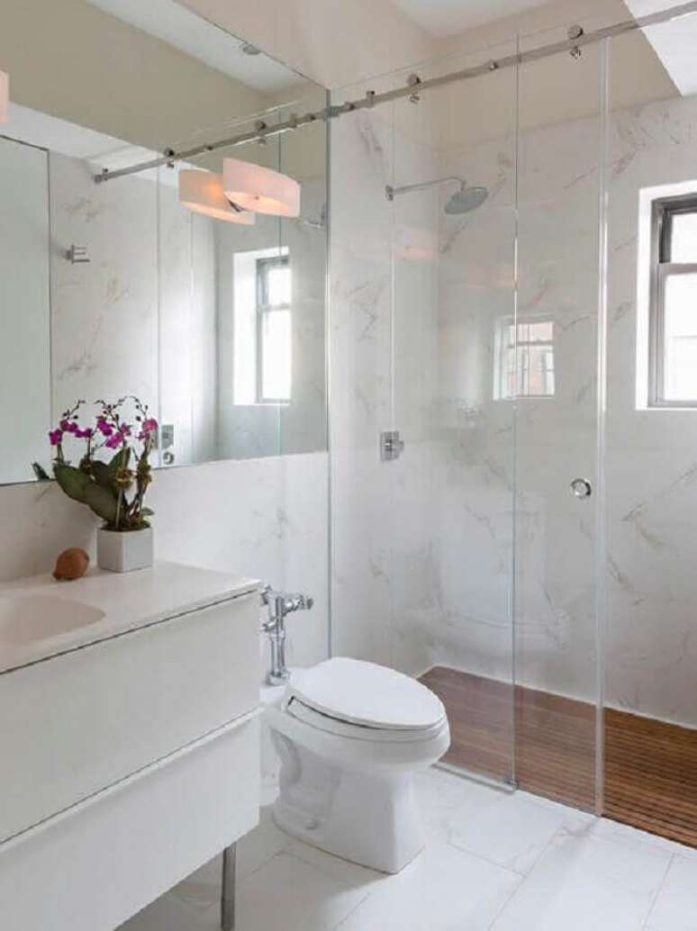 56. Revestimento para banheiro branco com piso de madeira – Foto: CoachDecor