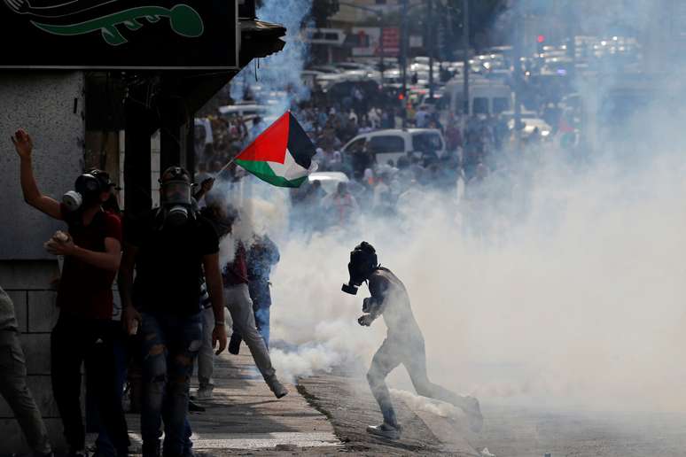 Manifestantes palestinos fogem de fumaça de gás lacrimogêneo lançado por forças israelenes durante protesto contra Israel em Belém 
14/11/2019
REUTERS/Mussa Qawasma