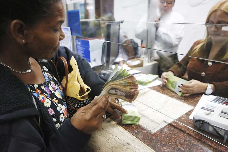 Mulher troca bolívares por dólares em casa de câmbio em Caracas
24/02/2015
REUTERS/Carlos Garcia Rawlins