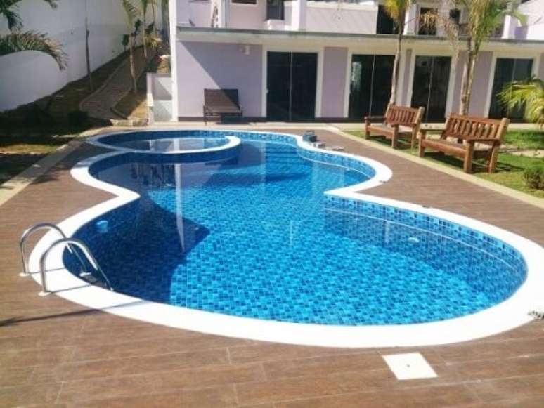 71. Piscina de vinil arredondada com piso de madeira em volta. Fonte: Caribe Piscinas