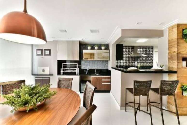 57. Varanda com churrasqueira integrada à cozinha com decoração moderna – Por: Tetriz Arquitetura
