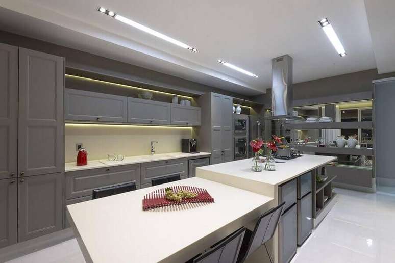 59. Cozinhas modernas com ilha grande e iluminação de led nos armários – Foto: Mariela Uzan