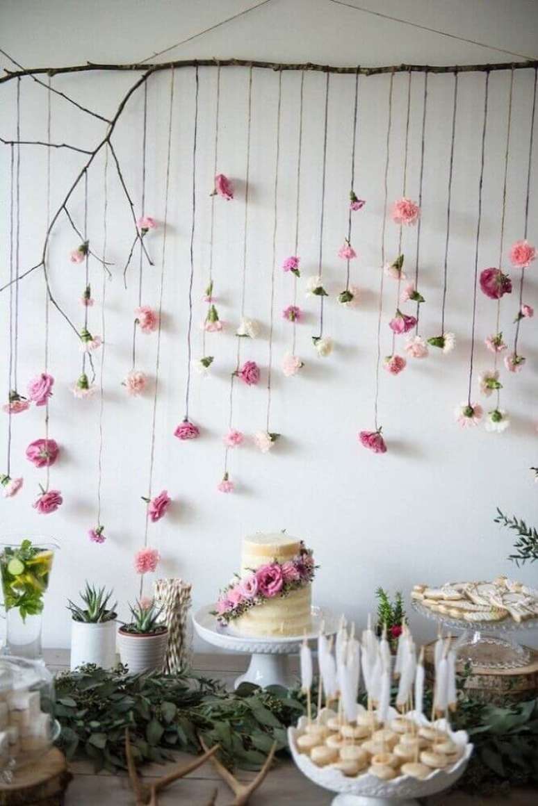 13. Decoração de chá de bebê com estilo rústico com folhagens na mesma e delicado painel com flores de papel ao fundo – Foto: Pinterest