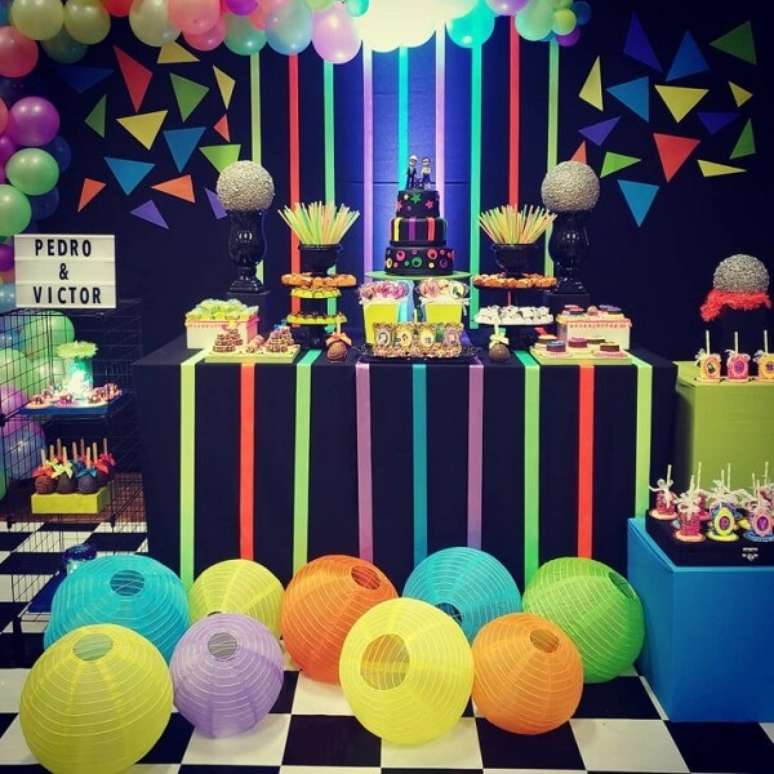 83. Invista em balões, fitas e acessórios coloridos para complementar a mesa do bolo. Fonte: Pinterest