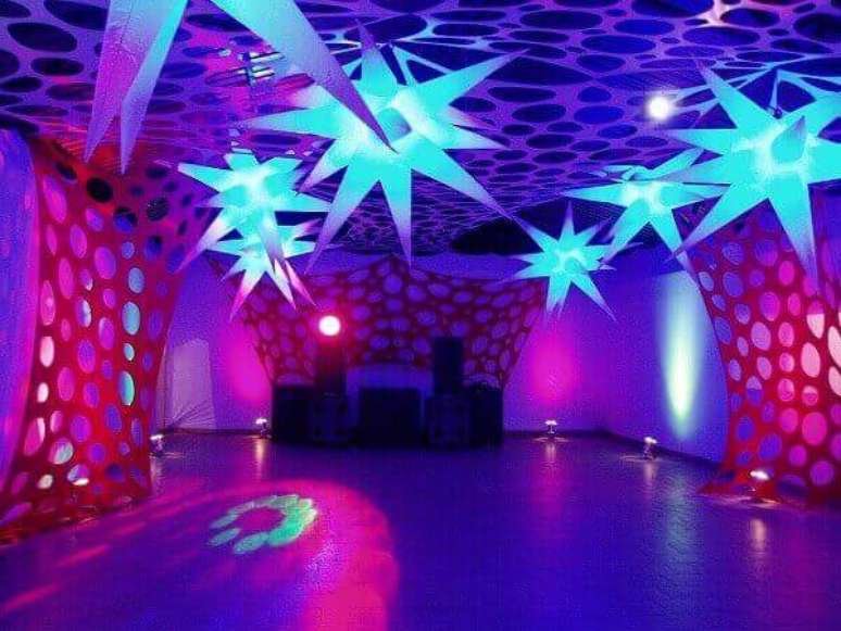36. Estrelas iluminadas para festa neon decoram o canto do salão reservado para dançar. Foto: Pinterest