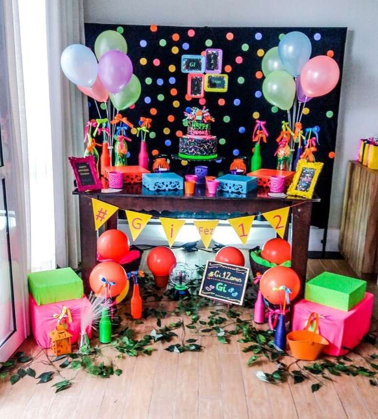 91. O móvel de madeira trouxe neutralidade para a decoração da festa neon. Fonte: Folia Eventos