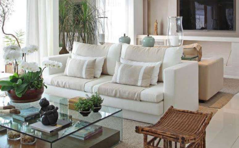 59. Sof&aacute; branco com decora&ccedil;&atilde;o em cores neutras e espelho na parede &ndash; Projeto: Negrelli e Teixeira