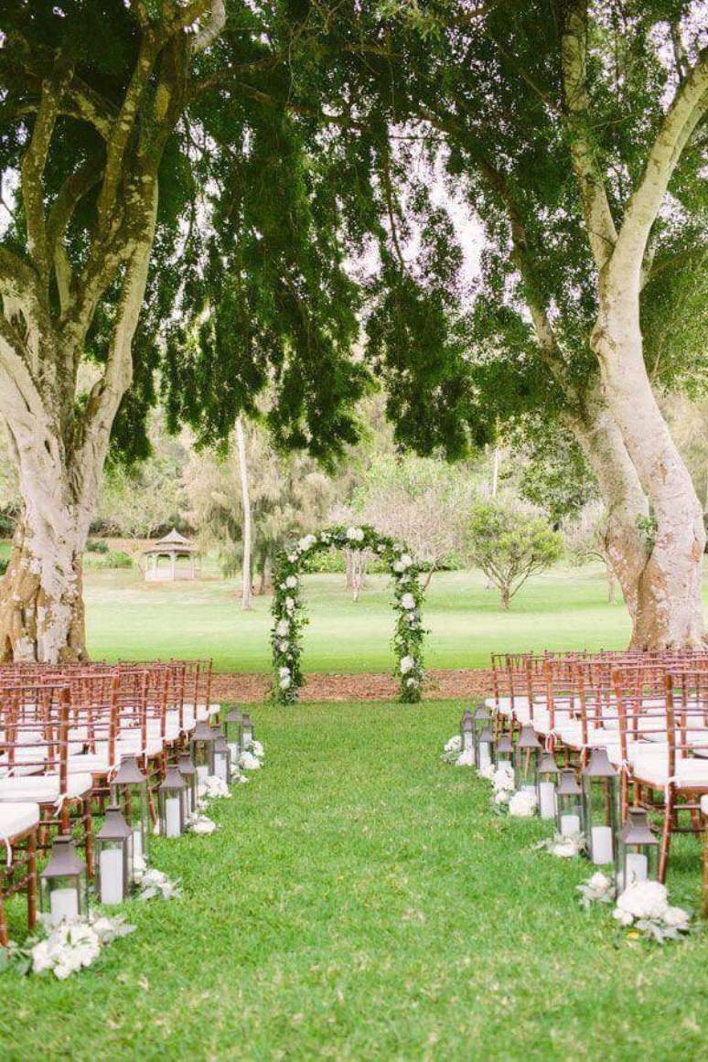 19. Decora&ccedil;&atilde;o para cerim&ocirc;nia de casamento simples ao ar livre com arco de flores e lanternas de velas &ndash; Foto: Elizabeth Anne Designs