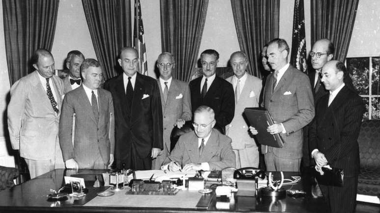 O então presidente dos EUA, Harry Truman (sentado), na cerimônia de assinatura da criação da Otan em 1949