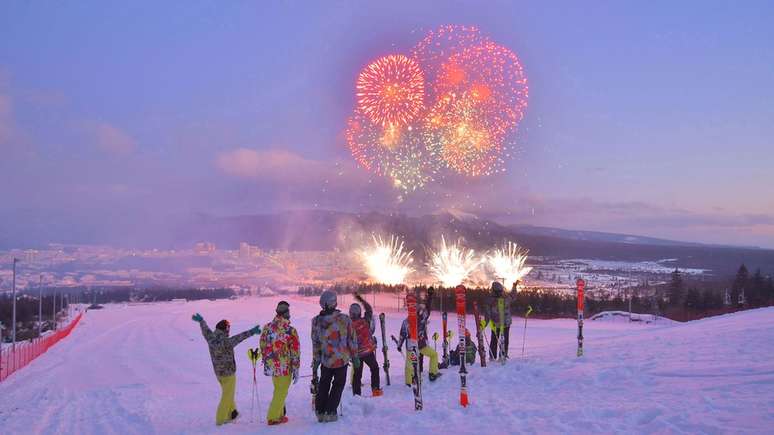 Pessoas comemoram a inauguração da cidade na estação de esqui