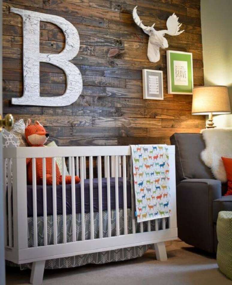 52. Quarto rústico de bebê com parede de madeira e quadros decorativos. Fonte: Pinterest