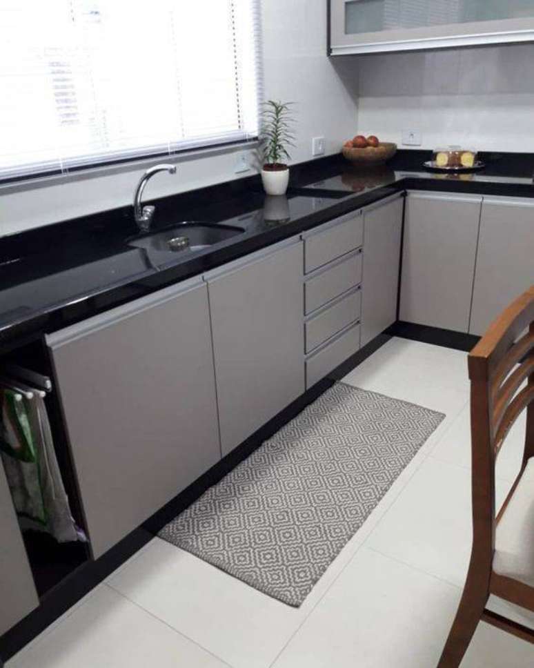 45. A bancada preta deixa a cozinha cinza mais moderna. Foto: Tua Casa