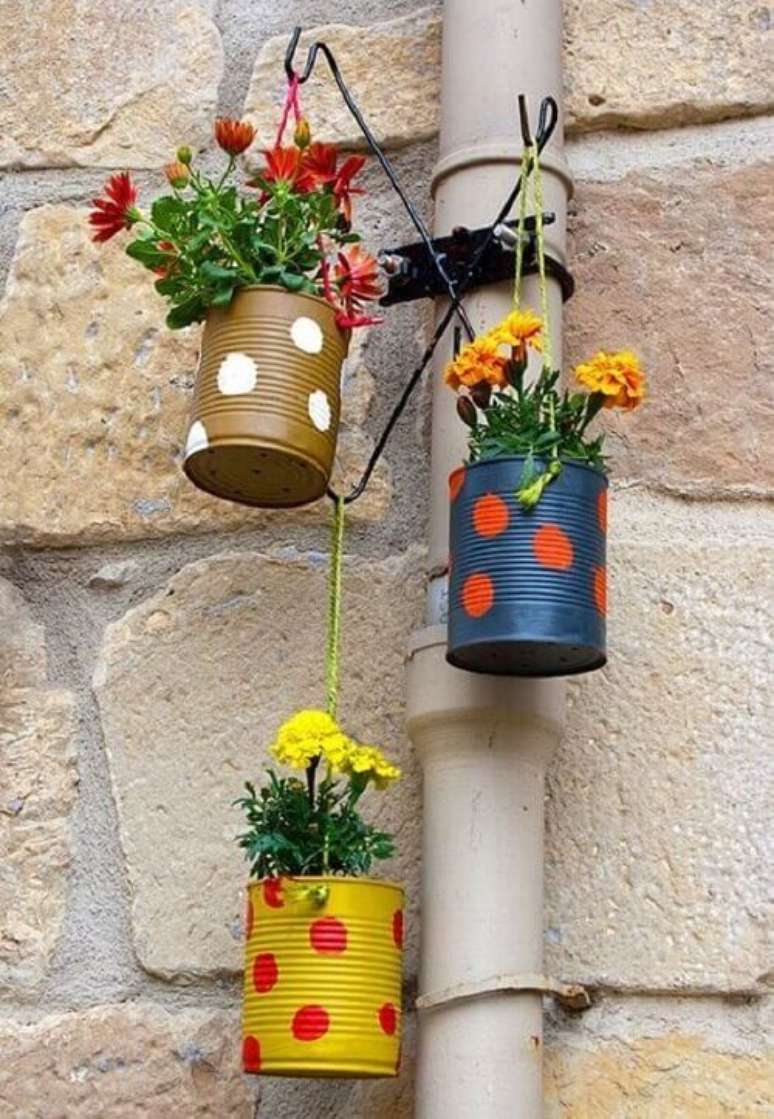 29. Latas decoradas formam o jogo de tr&ecirc;s vasinhos para enfeitar a varanda. Fonte: Pinterest